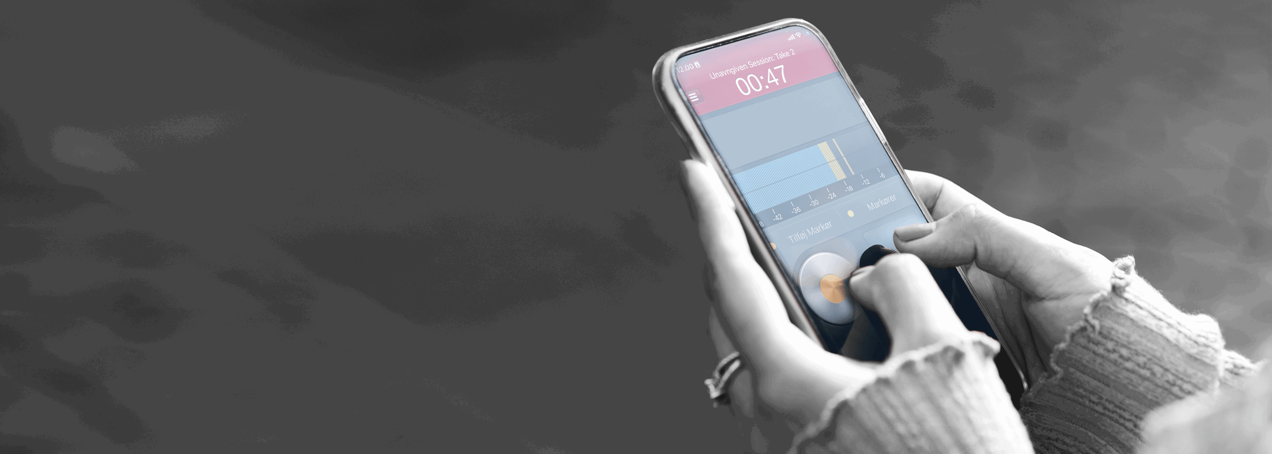 Person holding a smartphone using the Hindenburg Field Recorder app to record audio.