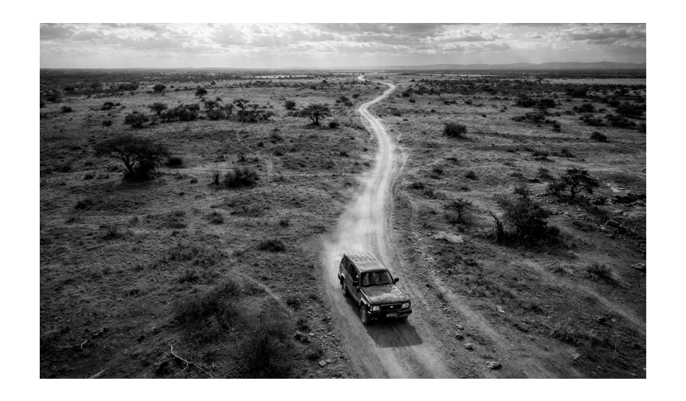 Nissan Patrol driving along a remote dirt road in the Zambian landscape
