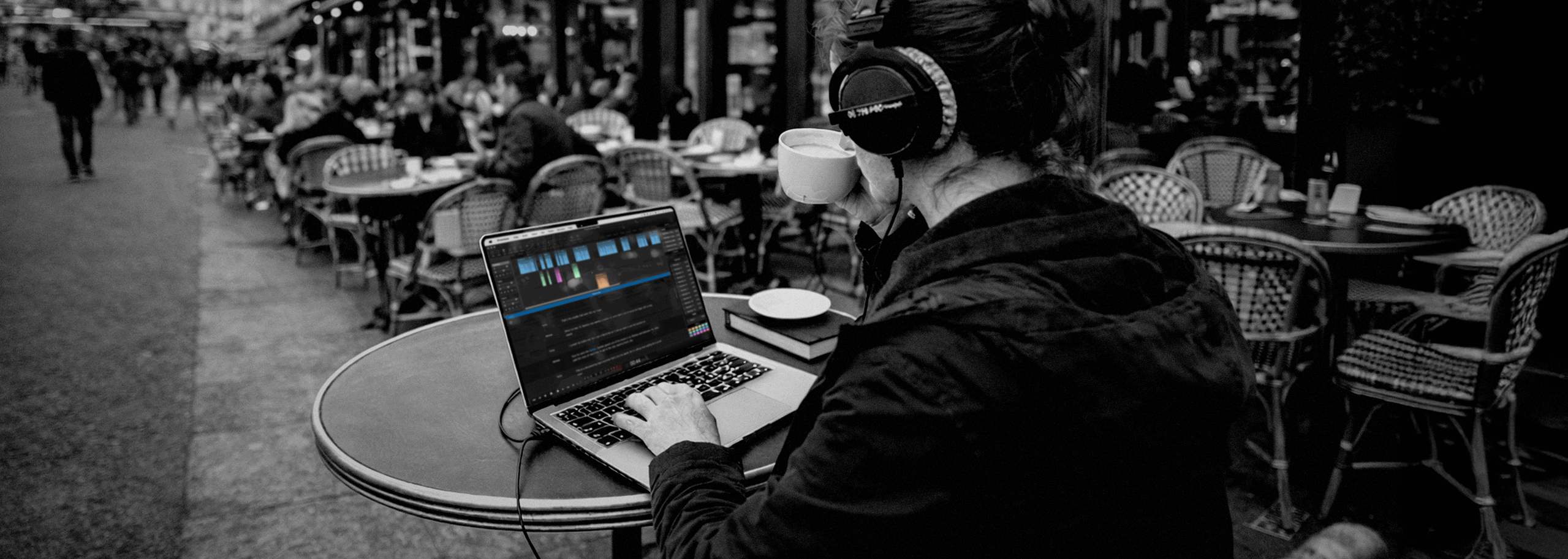 A female journalist edits an audio story in Hindenburg Pro while working offline at a café in the streets of Paris. Hindenburg Pro allows journalists and storytellers to edit professional audio from anywhere without relying on cloud connectivity.